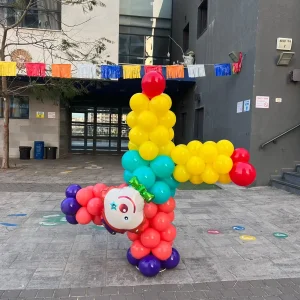 דמות ליצן מבלונים בתנוחת משחק לפורים - עיצוב צבעוני ודינמי